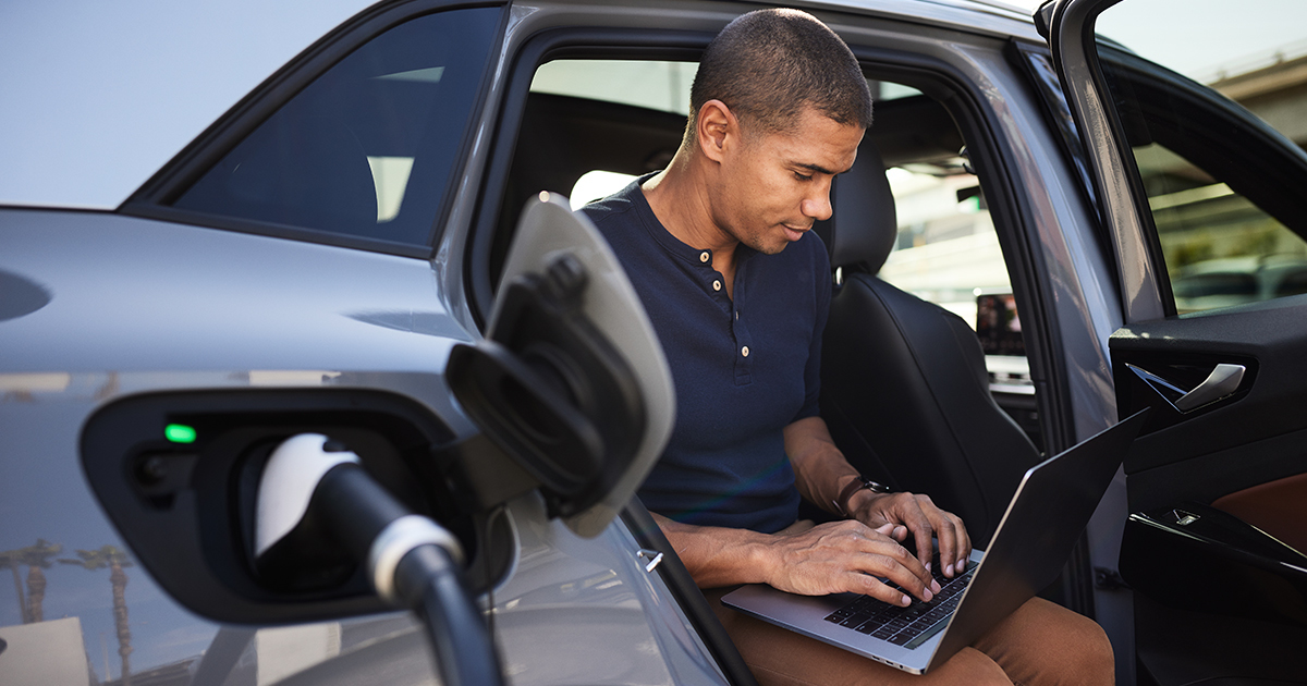 man_on_computer_charging_vehicle